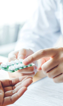 mani che tengono pillole e medicinali colorati