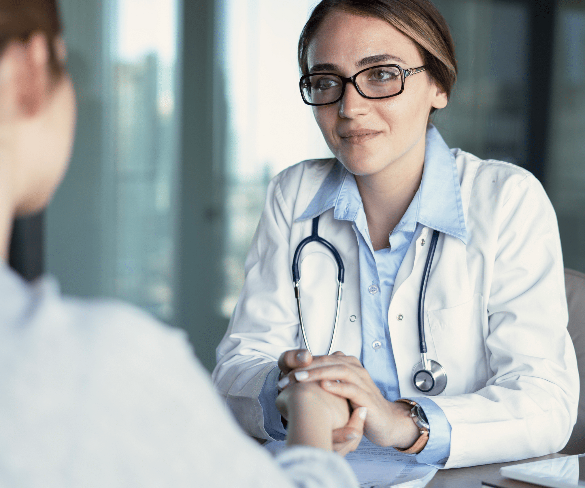 Ärztin mit Stethoskop im Gespräch mit Patient